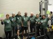 Group of over-40s clients at Transformation Fit Leicester celebrating in the gym in green shirts